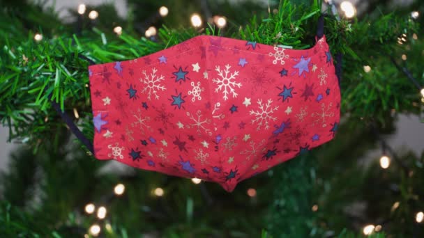 Die Weihnachtliche Covid Maske Hängt Als Dekoration Einem Grünen Baum — Stockvideo