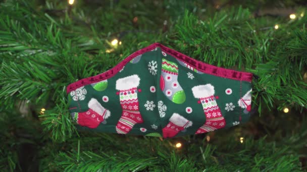 Die Weihnachtliche Covid Maske Hängt Als Dekoration Einem Grünen Baum — Stockvideo