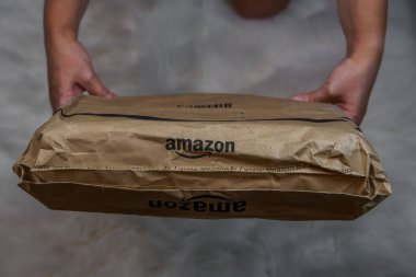 Amazon markası online teslimat kutusu konsepti. Çok uluslu teknoloji e-ticaret şirketinin şirket logosunu taşıyan sipariş paketi..