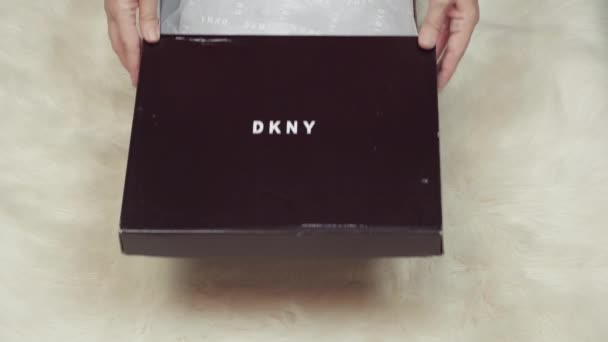 取消对Donna Karan的网上交货订单女性打开并展示包含一双印有公司标志的Dkny时髦鞋子的递送订单包 — 图库视频影像