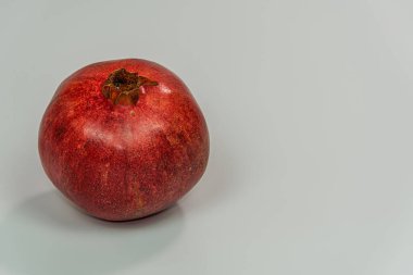 Beyaz arka plana karşı tüm taze nar. Kopyalama alanı ile kesilmemiş kırmızı meyve yakın plan.