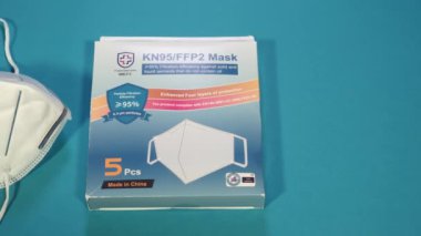 KN95 FFP2 covid-19 maske takip çekimi. Coronavirus 'un üst görüntüsünü% 95 partikül filtreleme verimliliği için kullanılan paket kutusuyla güçlendirilmiş korunmayla kapat.