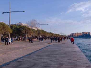 Selanik, Yunanistan 'da çok sayıda insan açık havada covid-19 maskeli. Şehir limanında kimliği belirlenemeyen, yüz koruması olan bir kalabalık yakın mesafeden yürüyor..