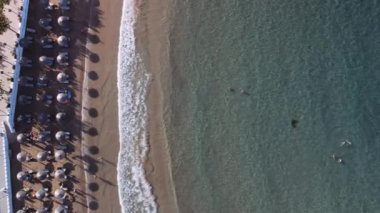 Akdeniz bölgesi Yunan plaj barı insansız hava aracı hala tanımlanamayan banyolarla çekiliyor. Girit adasındaki Georgioupoli 'nin hava manzarası kristal berrak, sakin deniz yatakları ve şemsiyeli deniz yatakları.