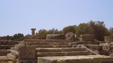 Olympia, Yunanistan 'ın antik spor oyunlarına ev sahipliği yapan arkeoloji sahası. Mavi gökyüzüne karşı sütunları olan Zeus 'un Dorik Tapınağı' ndan kalanlar..