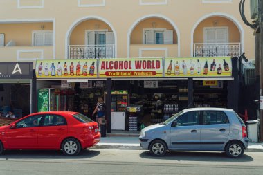Zakynthos, Yunanistan dışından büyük tabelalı içki dükkanının gündüz manzarası. Lagana Köyü 'nün ana caddesindeki İyon Adaları' ndaki içki dükkanının önünde..