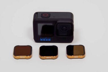 GoPro Kahraman 10 siyah logo üst görünümü ile. Çıkarılabilir lens kapaklı aksiyon kamerası ve beyaz arkaplana karşı değişken ND filtreleri.