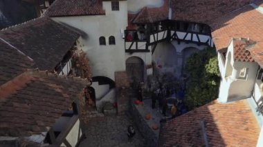 Bran Kalesi, Romanya - 01 Kasım 2023: Antik mimari ve canlı sonbahar dekorasyonları ile çevrili pitoresk bir avluda ziyaretçilerle birlikte.