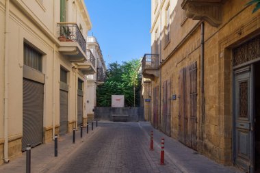 Lefkoşe, Kıbrıs - 20 Eylül 2025: Deniz mavisi kapılı Pastel cephesi, Türk Birlikleri 'nin işgal ettiği Kythrea Belediyesi ve mavi bir sokak plakası gösteriyor.