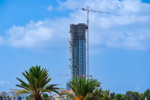 Kıbrıs Rum Kesimi 'nin Limasol kıyı şeridindeki palmiye ağaçlarının üzerinde inşaat halindeki yüksek kule yükseliyor.