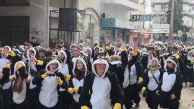 Xanthi, Yunanistan - 22 Şubat 2026: Kalabalık karnavalı kutluyor. Birçok insan neşeli atmosferden zevk alırken penguen kostümü giyer..