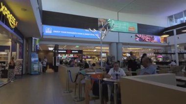 Paphos, Kıbrıs - 21 Eylül 2025: Gezginler havaalanının gıda salonu alanında çeşitli yemek ve içeceklerin tadını çıkarıyorlar.