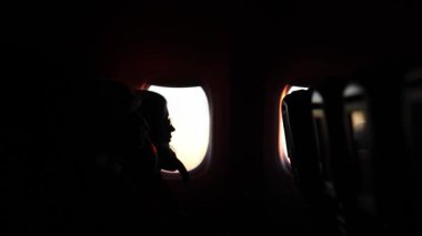 Uçağın penceresinin yanındaki kızın profili. Yüksek kaliteli FullHD görüntüler