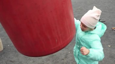 Küçük bir kız çocuk parkında kum torbasına çarpıyor. Yüksek kalite 4k görüntü