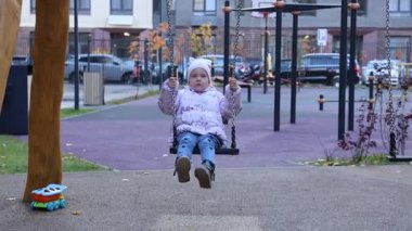 Küçük ikiz kardeşler sonbaharda salıncakta sallanıyor. Yüksek kalite 4k görüntü