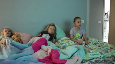 Üçüz kız kardeşler battaniyenin altında yatıyor. Yüksek kalite 4k görüntü