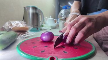 Bir kız küçük bir kırmızı soğan keser. Yüksek kaliteli FullHD görüntüler