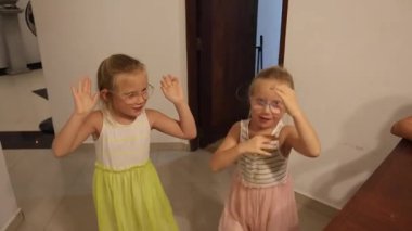 Küçük üçüz kız kardeşler mutfakta hamburger yiyorlar. Yüksek kaliteli FullHD görüntüler