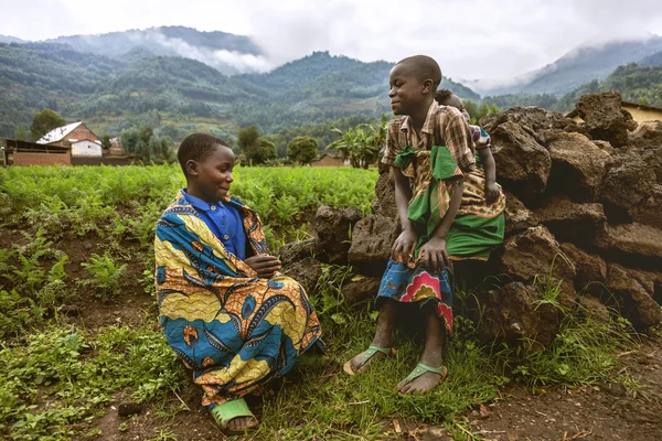 Barnen bär traditionella kläder sitter gräs. — Stockfoto