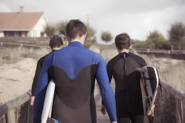 Three surfers on the way home — Stock Photo, Image