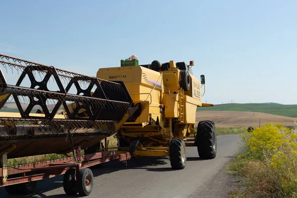 収穫の日の朝のアスファルト道路上の農業機械 — ストック写真