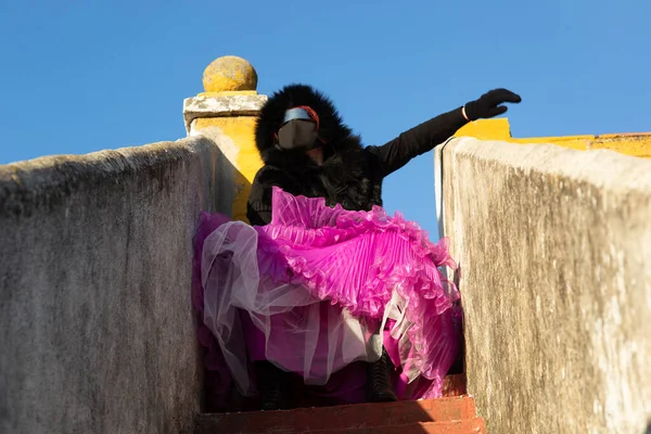 Siyah maskeli, gözlüklü ve kapüşonlu zarif bir kadın.