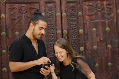 Genç çocuklar, güzergahı bulmak için akıllı telefondaki GPS haritasını kullanarak şehrin yolunu şaşırdılar.