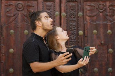 Genç çocuklar, güzergahı bulmak için akıllı telefondaki GPS haritasını kullanarak şehrin yolunu şaşırdılar.