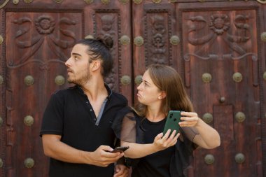 Genç çocuklar, güzergahı bulmak için akıllı telefondaki GPS haritasını kullanarak şehrin yolunu şaşırdılar.