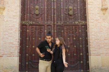 Genç çocuklar, güzergahı bulmak için akıllı telefondaki GPS haritasını kullanarak şehrin yolunu şaşırdılar.