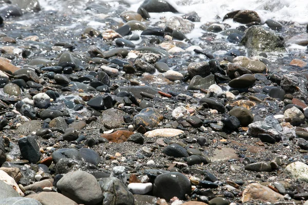 Orilla de la playa con rocas y agua de mar —  Fotos de Stock