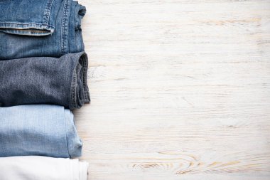 Ahşap arka planda üst manzarası olan kot pantolonlar. Metin için boşluk.