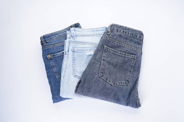 Üst görünümde beyaz arkaplanda izole edilmiş katlanmış kot pantolon..