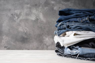 Gri arka planda katlanmış kot pantolon ve metin için boşluk.