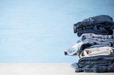 Kot pantolonlar ahşap bir arka planda dizilmiştir..