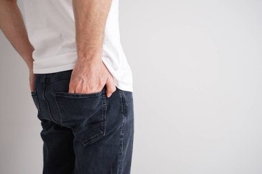 Gri arka planda kot giyen genç bir adamın bacakları, mesaj için yer..