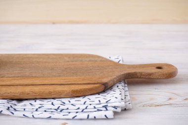 Gri arka planda mutfak havlusu olan ahşap kesme tahtası, mesaj için uygun bir yer. Yakın plan..
