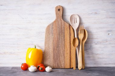 Tahta kesme tahtası ve ahşap arka planda sebzeler..