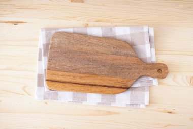 Tahta kesme tahtası ve ahşap arka planda mutfak havlusu, mesaj için yer. Düz yatıyordu.