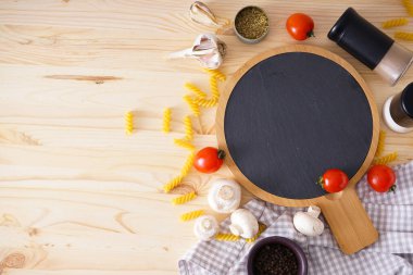 Tahta kesme tahtası ve ahşap masa arkasında yemek pişirmek için taze malzemeler, yazı için yer. Düz yatıyordu.