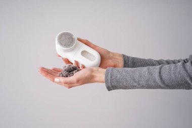 Modern kumaş traşlı ve arka planda giysileri olan kadın eli.