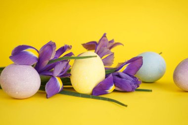 Sarı arka planda çiçekli Paskalya yumurtaları.