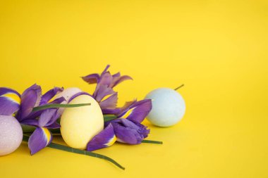 Sarı arka planda çiçekli Paskalya yumurtaları, metin için boşluk.
