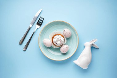 Paskalya bayramı sofrası ve mavi arka planlı renkli yumurta tabakları. Paskalya tatili konsepti. Düz yatıyordu.