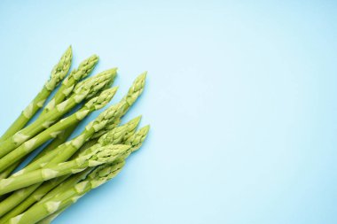 Mavi arka planda yeşil taze kuşkonmaz, mesaj için yer var. Yakın plan.