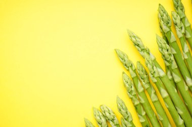 Sarı arka planda yeşil taze kuşkonmaz, metin için yer.