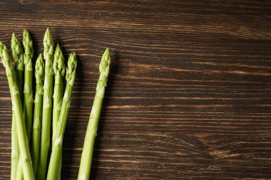 Fresh asparagus on wooden background, space for text. Flat lay.