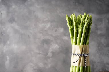 Gri arkaplanda taze kuşkonmaz, metin için boşluk. 