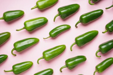 Pembe arka planda Jalapeno biberleri. Düz yatıyordu.