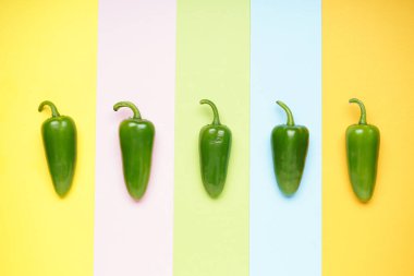 Renkli arka planda yeşil biberler. Düz yatıyordu. 